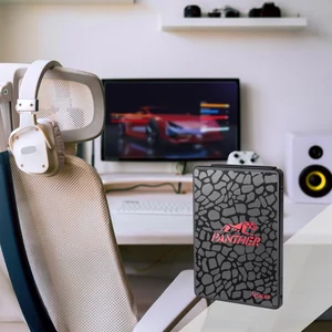 Disco Apacer AS350 Panther ao pé de uma secretária com monitor, colunas e cadeira
